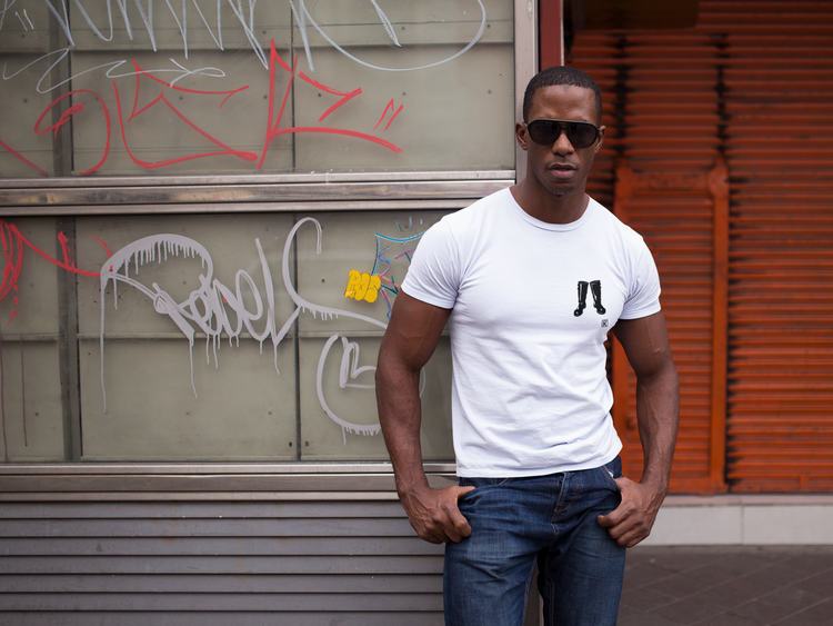 man-standing-in-a-white-t-shirt-against-a-wall