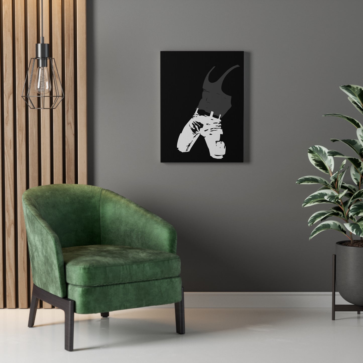 Green armchair in a room with a gray wall, framed artwork, and a plant.