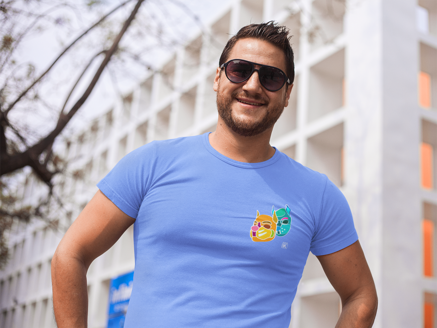 Man wearing a blue t-shirt with a colourful graphic outdoors