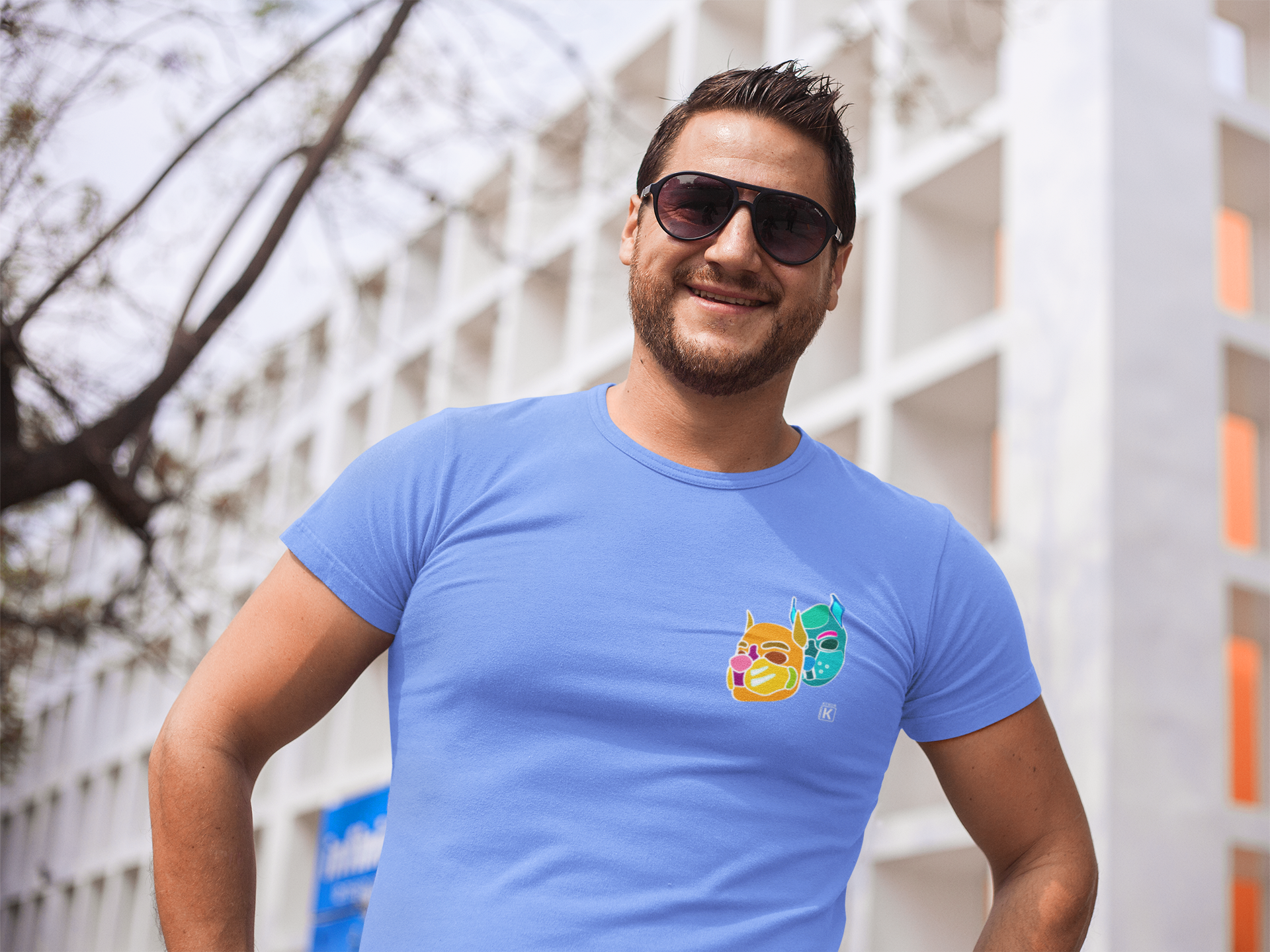 Man wearing a blue t-shirt with a colourful graphic outdoors